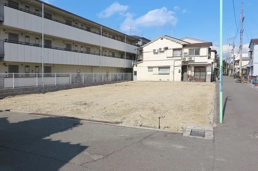 空の土地と住宅街の風景