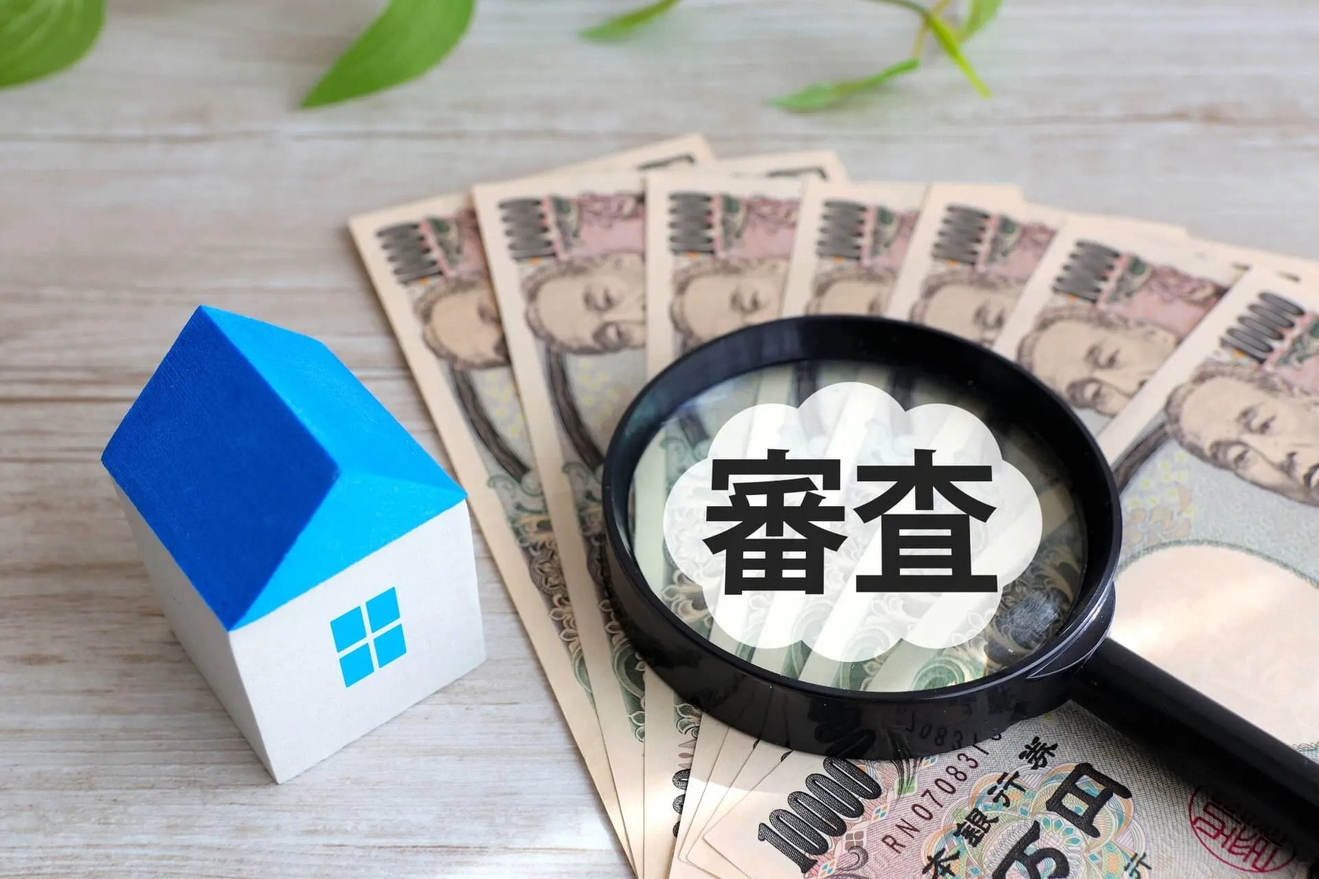 家の模型と審査中のお金